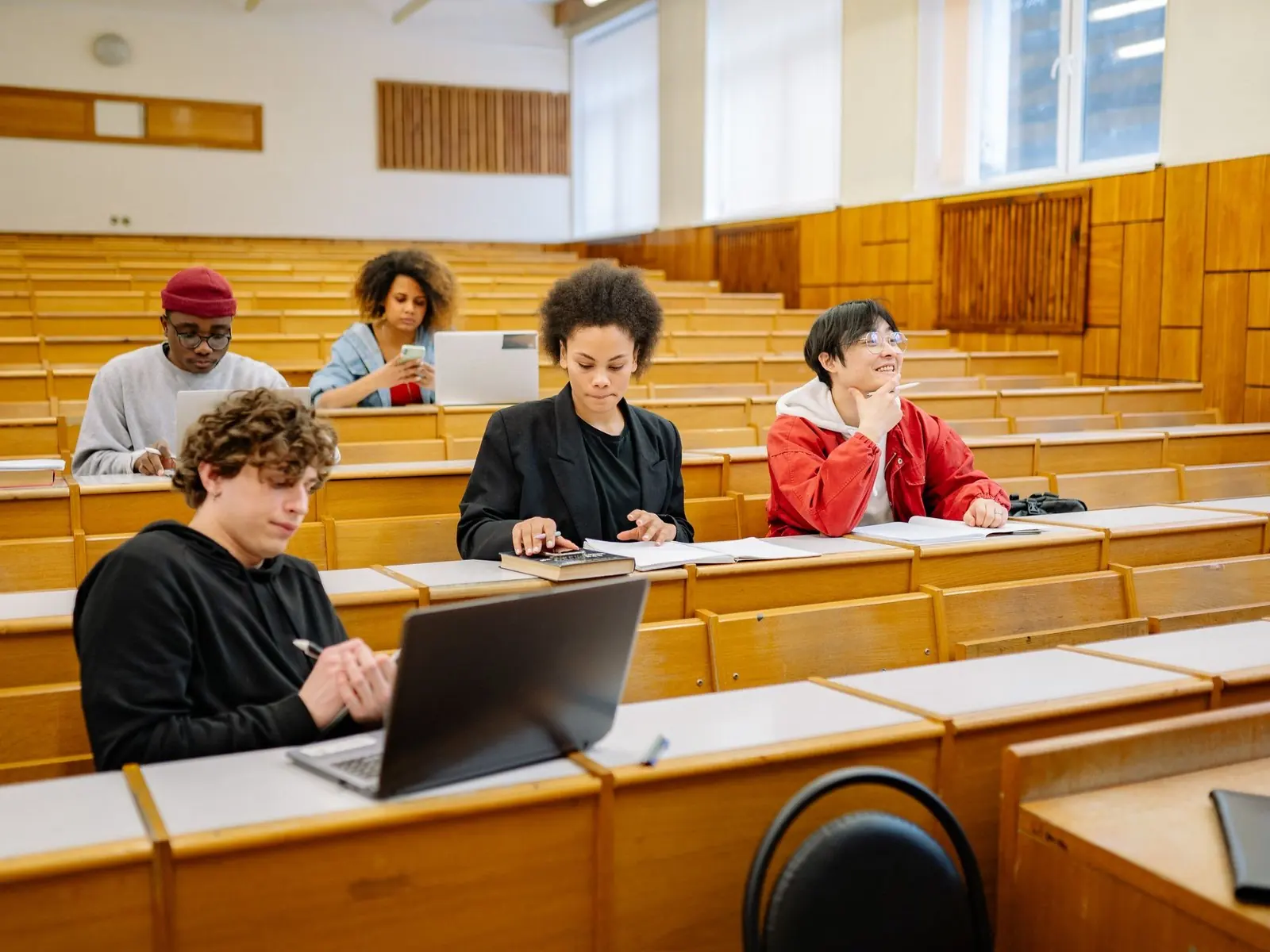Estudiantes en un auditorio con sus portátiles