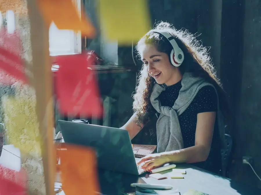 Estudiante trabajando con su portátil y audífonos