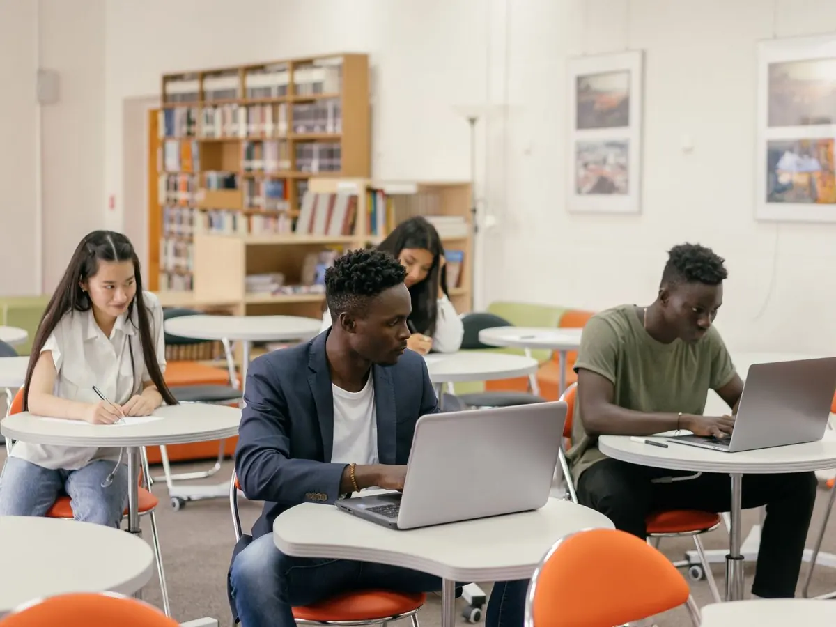 Estudiantes con portátiles en un aula de la sede