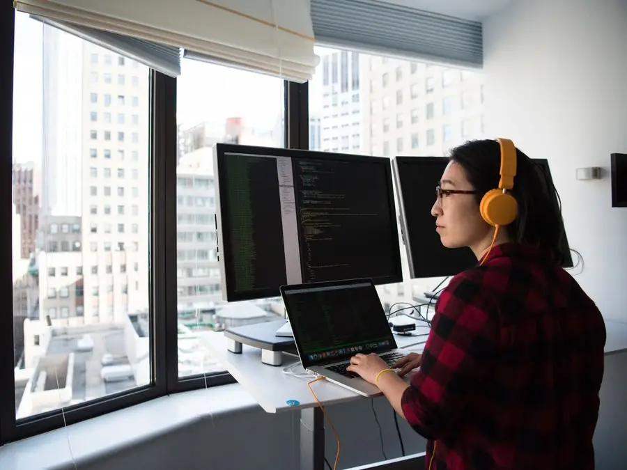 Desarrolladora programando en un escritorio de pie